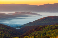 cold morning fog with red hot sunrise in the mountains in the morning