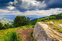 big white square stone on top of the mountain before the summer storm